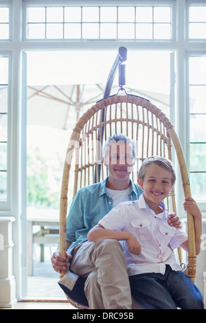 Père et fils assis dans wicker chair Banque D'Images