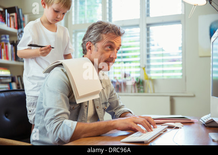 Fils Père de distraction au travail en home office Banque D'Images