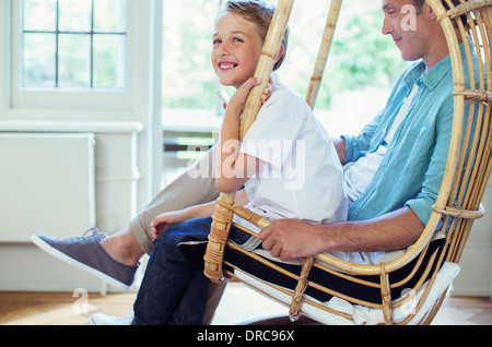 Père et fils assis dans wicker chair Banque D'Images