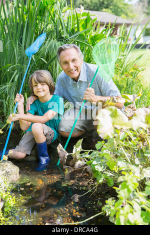 Grand-père et petit-fils de pêche dans étang Banque D'Images