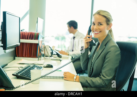 Businesswoman talking on telephone in office Banque D'Images