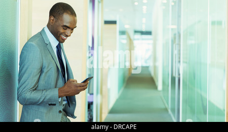 Businessman using cell phone in office Banque D'Images