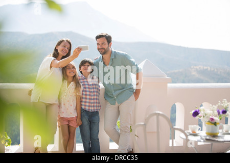 Family taking self-portrait sur balcon ensoleillé Banque D'Images