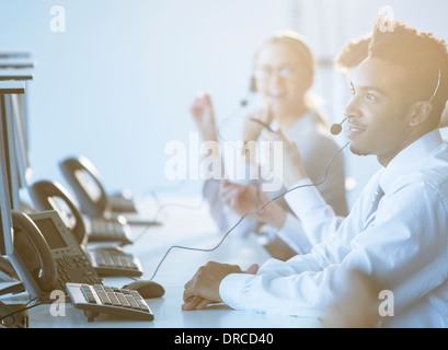 Businessman talking on headset in office Banque D'Images