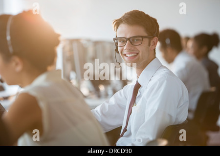 Businessman wearing headset in office Banque D'Images