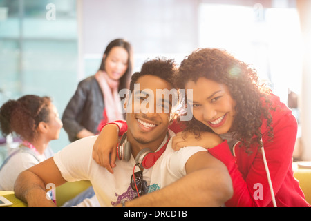 Young couple smiling in lounge Banque D'Images