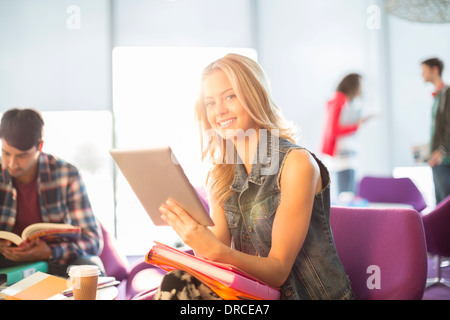 Étudiant universitaire using digital tablet in lounge Banque D'Images