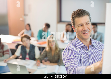 Le professeur écrit sur le tableau blanc en classe Banque D'Images