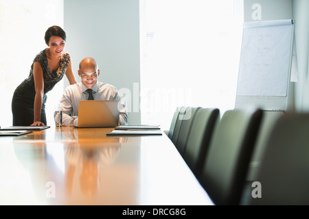 Les gens d'affaires travaillant à l'ordinateur portable dans la salle de conférence Banque D'Images