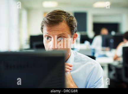 Surpris businessman at computer in office Banque D'Images