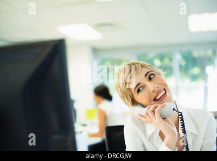 Businesswoman talking on telephone in office Banque D'Images