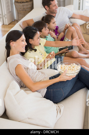 Family watching film sur un canapé dans la salle de séjour Banque D'Images