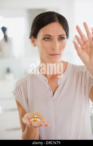 Woman examining comprimés dans la salle de bains Banque D'Images