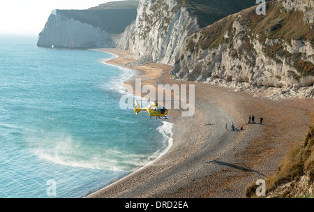 Dorset et Somerset Air Ambulance secourir une dame à Durdle Door Beach sur la Côte Jurassique, près de crique de Lulworth, Dorset, England, UK Banque D'Images