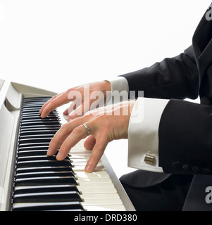 Man in tuxedo jouer du piano isolé sur fond blanc Banque D'Images