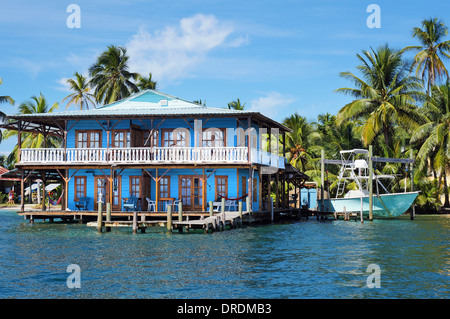 Belle maison tropicale sur pilotis sur la mer des Caraïbes avec un bateau et des cocotiers, le Panama Banque D'Images