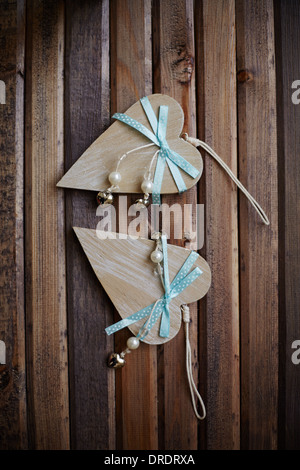 Image de coeurs en bois avec perles et rubans bleus sur fond de bois Banque D'Images