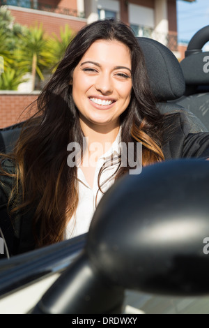 Une jeune femme d'affaires réussie dans une luxueuse voiture sport décapotable Banque D'Images