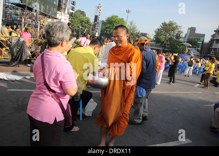 Des manifestants anti-gouvernement qui mérite à des moines bouddhistes de payer pour le Roi Bhumibol Adulyadej de Thaïlande sur son 86e naissance Banque D'Images