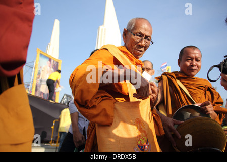 Des manifestants anti-gouvernement qui mérite à des moines bouddhistes de payer pour le Roi Bhumibol Adulyadej de Thaïlande sur son 86e naissance Banque D'Images