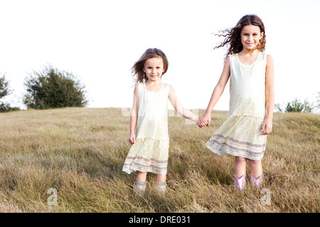 Soeurs en robes standing in field Banque D'Images