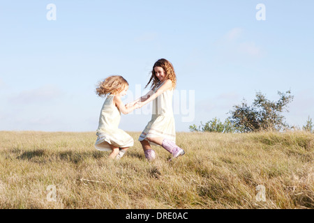 Soeurs en robes standing in field Banque D'Images