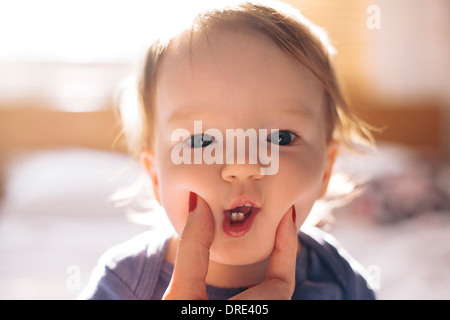 Pincer les joues de bébé mignon Banque D'Images