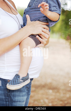 Maman enceinte holding Young boy on bosse bébé Banque D'Images