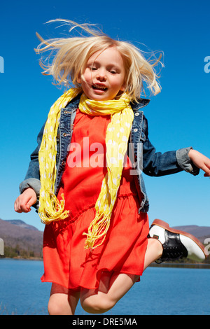 Girl in red dress by lake Banque D'Images