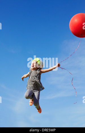 Saut man en l'air avec un ballon rouge Banque D'Images