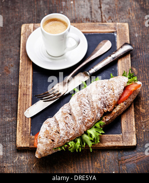 Sandwich au saumon fumé et de café sur ardoise tableau vintage background Banque D'Images