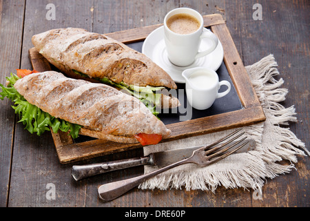 Sandwich au saumon fumé et de café sur ardoise tableau vintage background Banque D'Images
