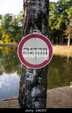 Propriete privee, défense d'entrer signe cloué à l'arbre par le lac de pêche privé dans la région de Montcigoux, Dordogne, France Banque D'Images