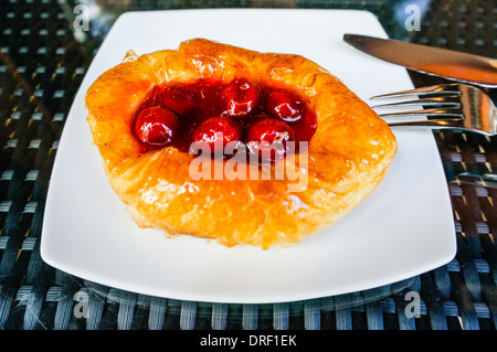 Cerise frais pâte dans un plat en porcelaine. placé sur une table avec table en verre réfléchissant Banque D'Images