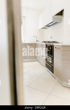 Cuisine moderne avec intérieur en bois. Porte en verre à l'avant-plan Banque D'Images