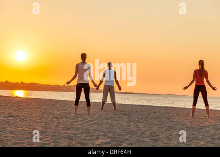 Les personnes pratiquant le yoga sur la plage, soleil yoga faire Banque D'Images