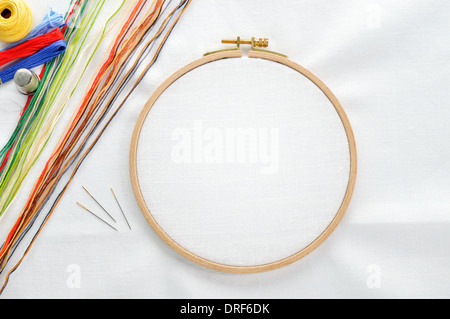 Jeu de broderie. Tissu en lin blanc, broderie hoop, fils colorés et needls. Copier l'espace. Banque D'Images