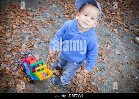 Toddler Playing with toy parmi les feuilles d'automne, Osijek, Croatie Banque D'Images