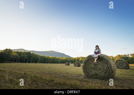 L'état de New York USA hay bales fille assise sur le dessus de la balle Banque D'Images