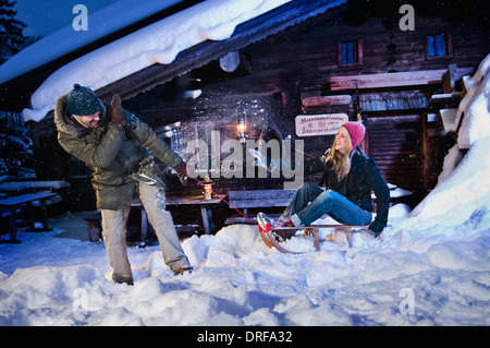 Homme Femme tirant sur le traîneau, Log Cabin en arrière-plan, Tyrol, Autriche, Europe Banque D'Images