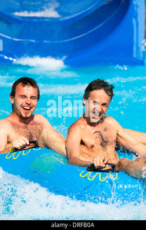 Deux hommes s'amusant, les gens toboggan à Aqua park. Banque D'Images