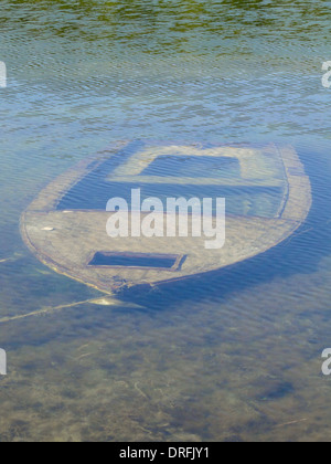 Petit bateau de pêche est allongé sur le sol d'un lac peu profond. Banque D'Images