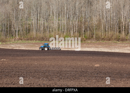 Tracteur labourer le champ au début du printemps Banque D'Images