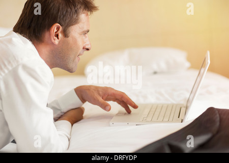 Young man using laptop in hotel room, Dubrovnik, Croatie Banque D'Images