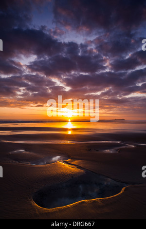 Vue au lever du soleil à la fin de l'été à partir de la plage de Bamburgh Northumberland en regardant vers les îles Farne Banque D'Images
