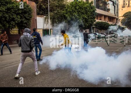 Le Caire, Égypte. 25 Jan, 2014. Des manifestants anti-militaires s'enfuient de gaz lacrymogènes tirés par la police près de la place Ramsès, le centre-ville de Caire, Égypte, Jan 25, 2014. Des heurts ont éclaté entre la police anti-émeute et les manifestants à travers le pays comme les Égyptiens ont organisé des rassemblements pour marquer le troisième anniversaire de l'un bouleversement qui a renversé la règle de 30 ans, Hosni Moubarak, le samedi. Credit : Amru Salahuddien/Xinhua/Alamy Live News Banque D'Images