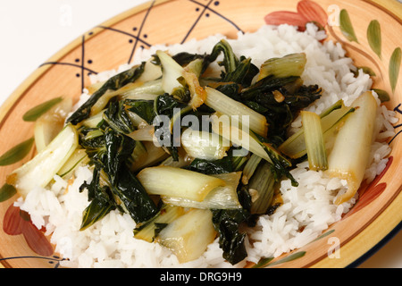 Une plaque avec le bok choi sauté de chou asiatique et haché avec l'huile de sésame et la sauce de soja, servi sur un lit de riz au jasmin blanc Banque D'Images