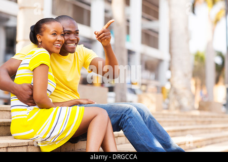 Happy African American couple assis à l'extérieur dans la ville Banque D'Images