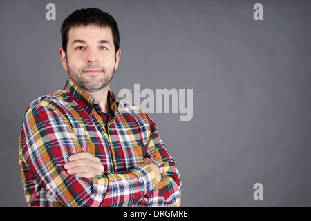 Confiant, fiable, sympathique homme d'âge moyen, homme ordinaire sur gris Banque D'Images