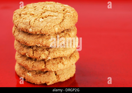 Pile de beurre de cacahuète fait maison et biscuits sur fond d'émail rouge Banque D'Images